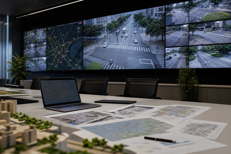 Sala de monitoramento urbano com telas de câmeras e documentos de planejamento, capa da matéria sobre Santo André no Fórum de Lisboa